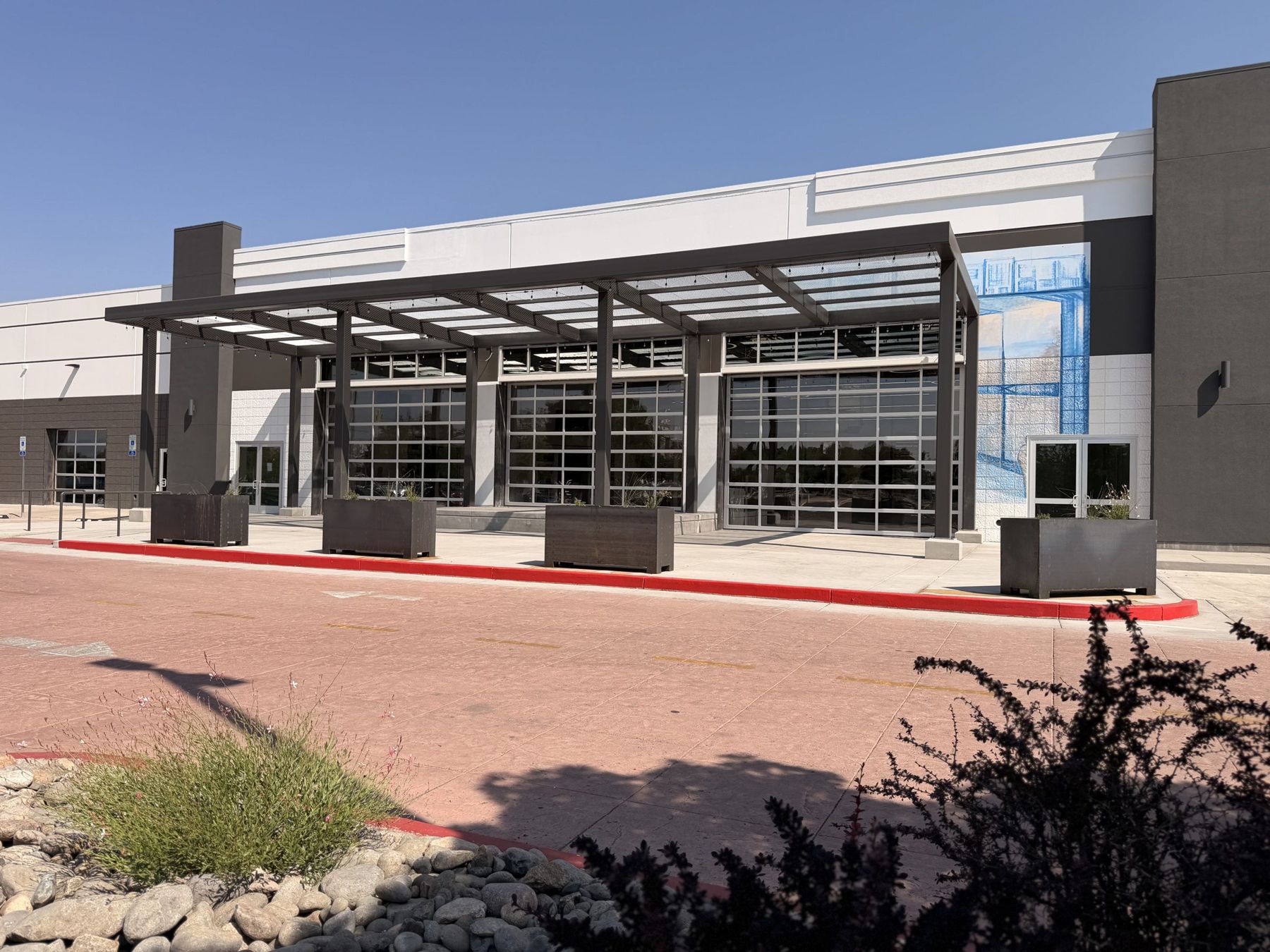 The Oddie District entrance: steel canopy and glass garage doors
