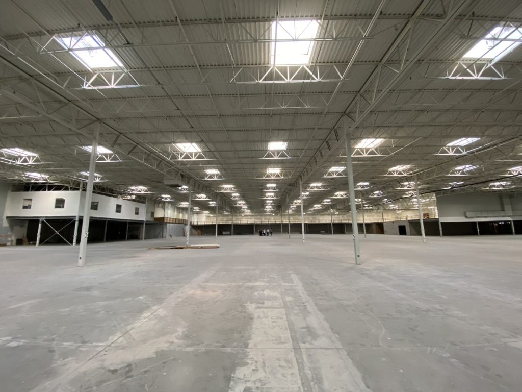 Then: the empty Lowe's floor, bare concrete under skylights
