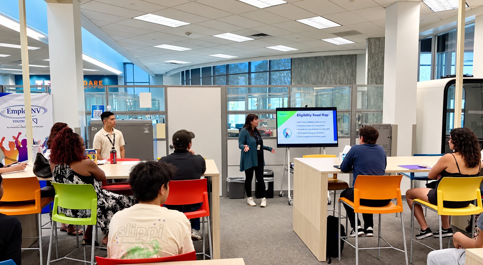 A career coach walks a group of young adults through a program road map at the EmployNV Career Hub