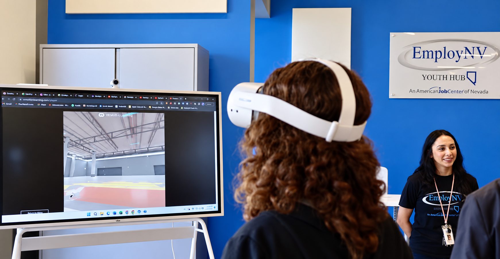 A young woman in a VR headset explores a virtual warehouse at the EmployNV Career Hub